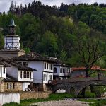 Красива българска планинска село с традиционна архитектура и зелена природа.