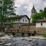 Обзор на живописен български село с река, историческа архитектура и църква, подходящ за туризъм и културно наследство.