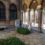 Античен двор в България с каменна настилка и скулптури.