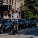 A street in Bulgaria, a man riding an electric scooter, an urban landscape, a modern way of getting around.