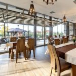 Комфортна зала за хранене в Хилвийю България с изглед към външната тераса.